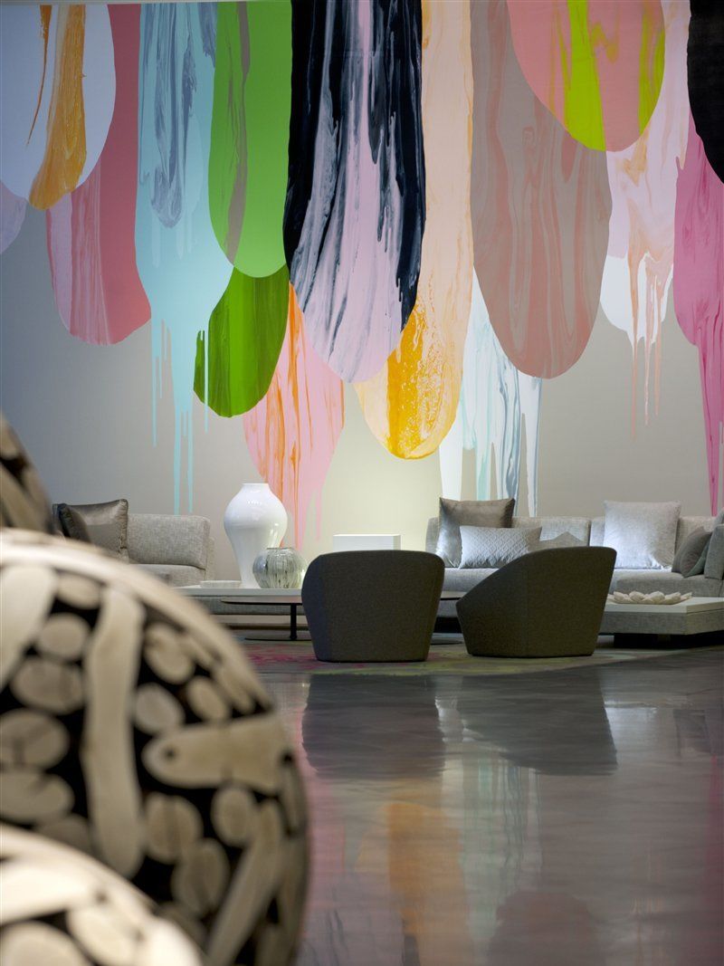 Crown Metropol Melbourne Hotel Exterior foto The photo shows a modern interior space featuring contemporary furniture and a striking wall mural. The mural consists of colorful paint drips in shades of pink, green, yellow, and black, creating an artistic backdrop. In the foreground, there are tw